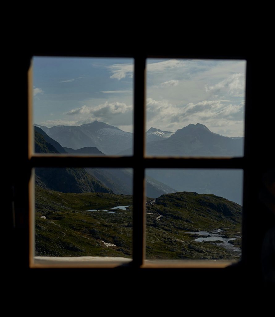 pexels-photo-34408237-34408237 Majestic mountain landscape viewed through a window, capturing natural beauty and tranquility.